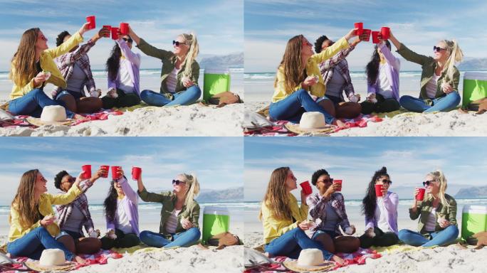 快乐的一群不同的女性朋友在海滩上玩得开心，野餐