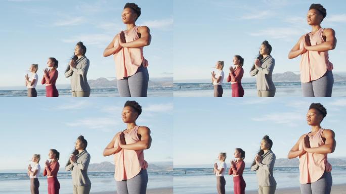 一群不同类型的女性朋友在沙滩上练习瑜伽
