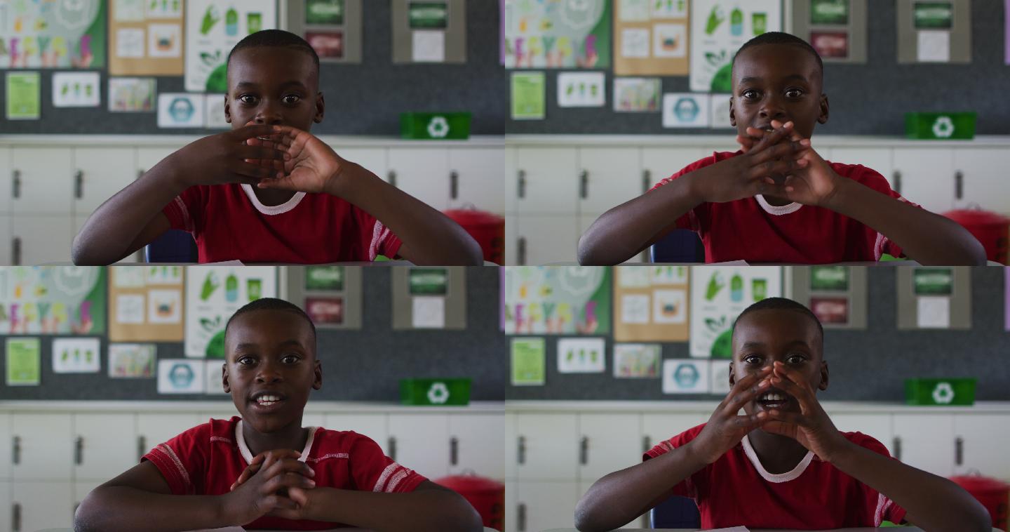 非裔美国学生的肖像坐在教室里，回答问题，看着相机