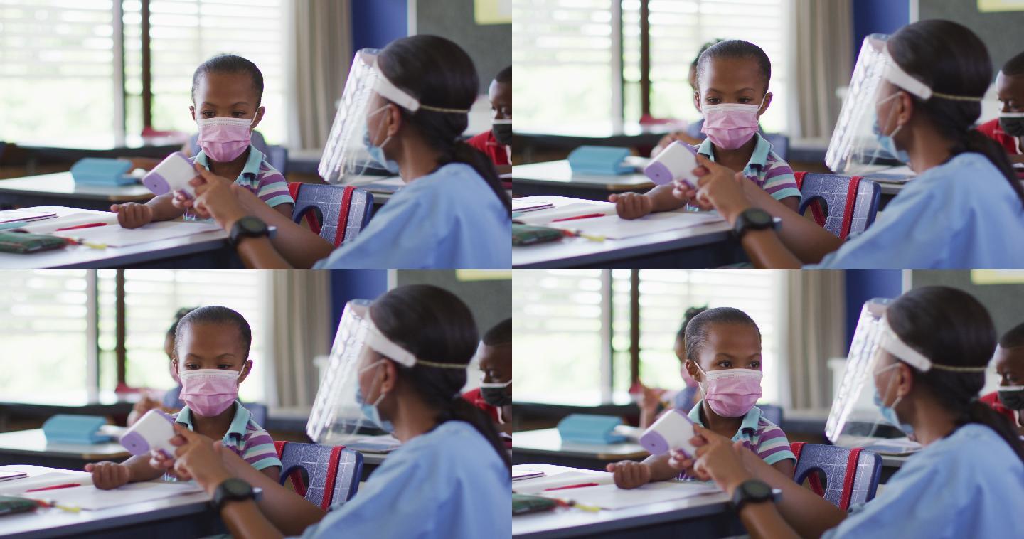 医务人员向女学生展示如何测量温度，所有人都戴着口罩，