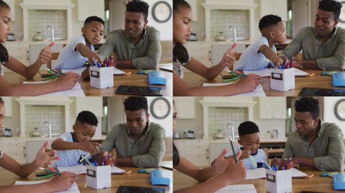 非裔美国父亲，女儿和儿子坐在厨房的桌子上做作业