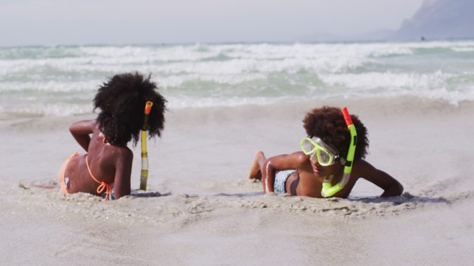 非裔美国儿童戴着潜水镜在海滩上玩耍