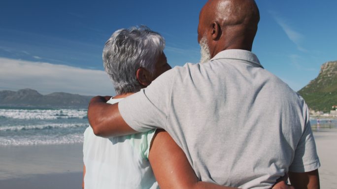 一对非洲裔美国老夫妇在海滩上拥抱