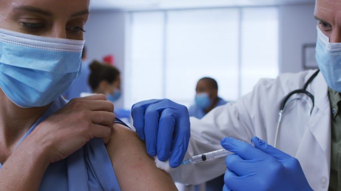 医护人员工作场景外国接种新冠疫苗医生打输