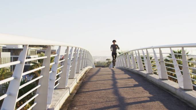 健康的非裔美国人在城市户外运动，在人行天桥上跑步