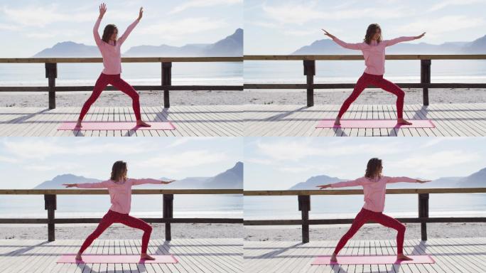 健康的混血女子在户外练习瑜伽，站在海边伸展身体