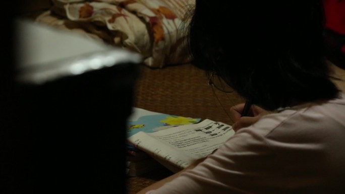 山村农村留守儿童晚上灯光下做作业学习看书