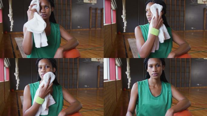 非裔美国女篮球运动员休息和使用毛巾的肖像