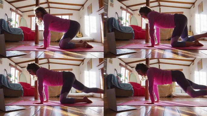 轻松的混血女子练习瑜伽，跪在阳光明媚的小屋卧室伸展