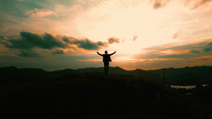 企业家，西装男人登顶山峰张开双臂拥抱太阳