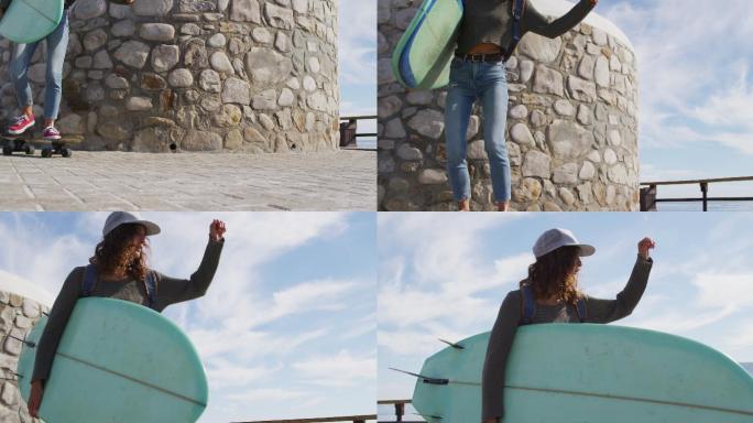 快乐的混合种族妇女滑板携带冲浪板在阳光明媚的海滨散步