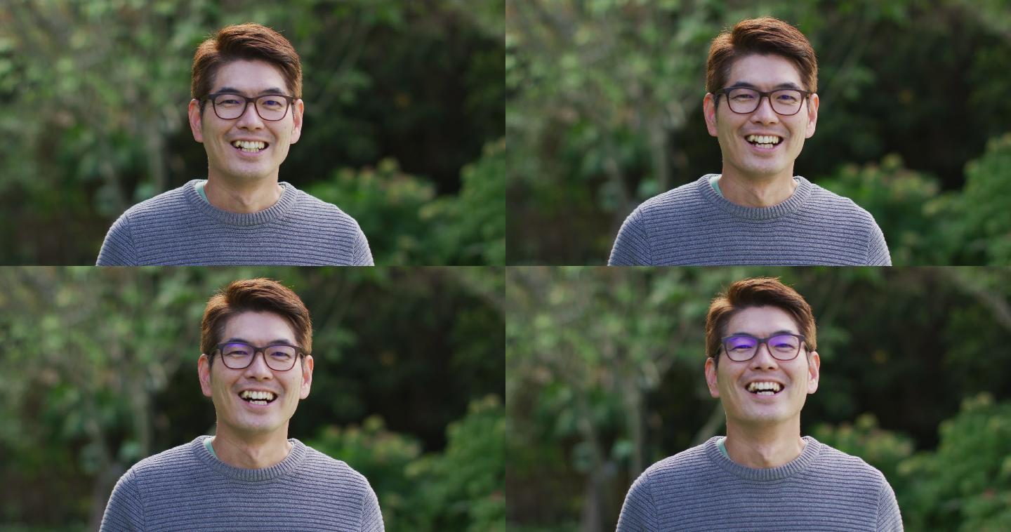 快乐的亚洲人的肖像看着照相机微笑和大笑在花园