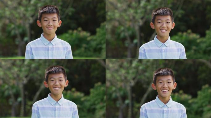 快乐的亚洲男孩的肖像看着照相机微笑和大笑在花园