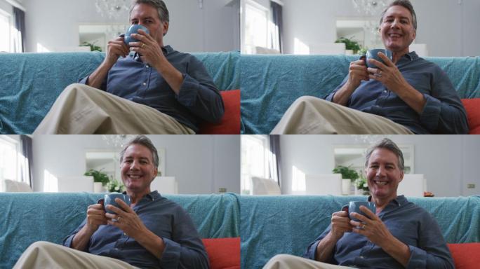 快乐的老年白人男人的肖像坐在客厅喝咖啡和微笑