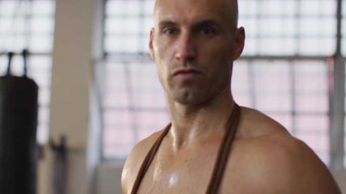 身材匀称的白人男子在健身房脖子上套着跳绳的肖像