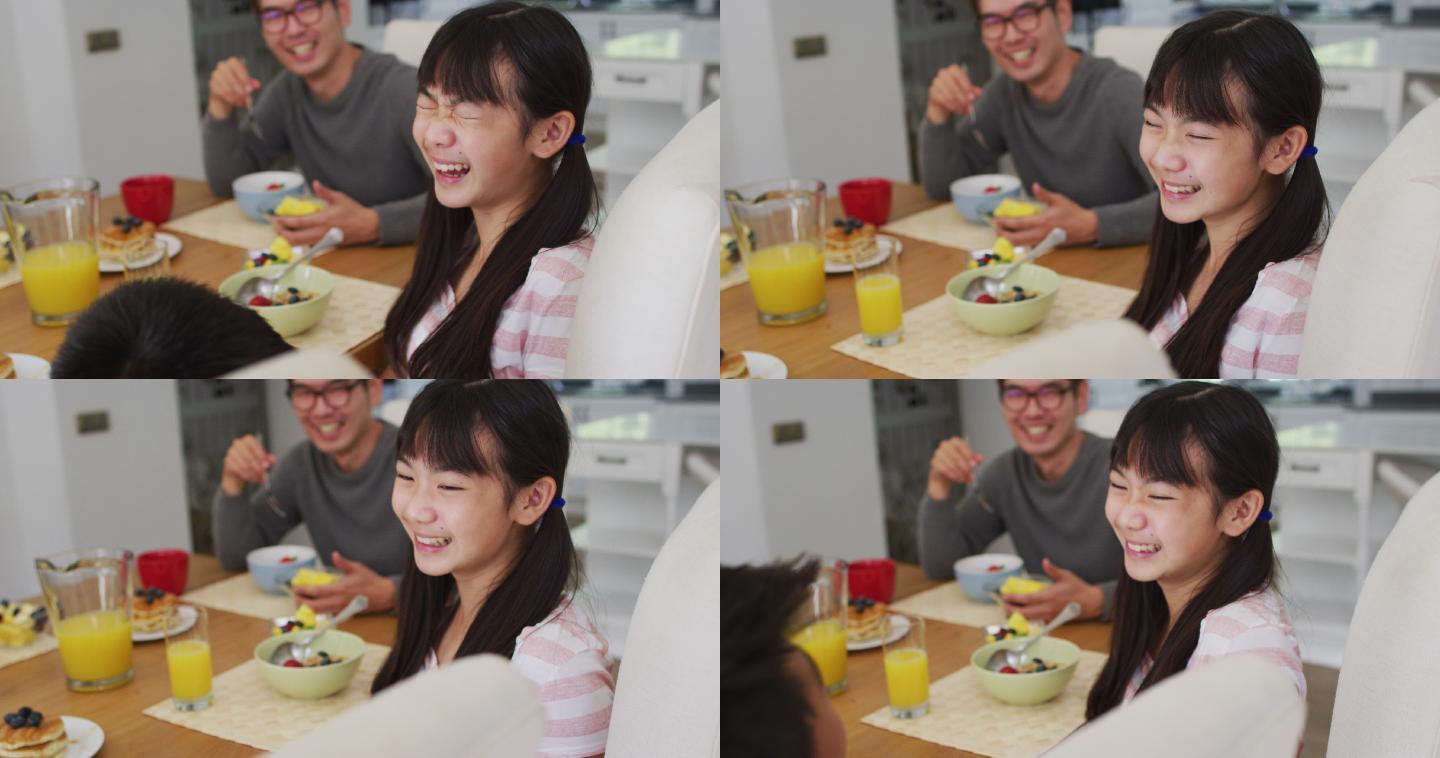 快乐的亚洲父亲在厨房吃早餐，笑儿子和女儿