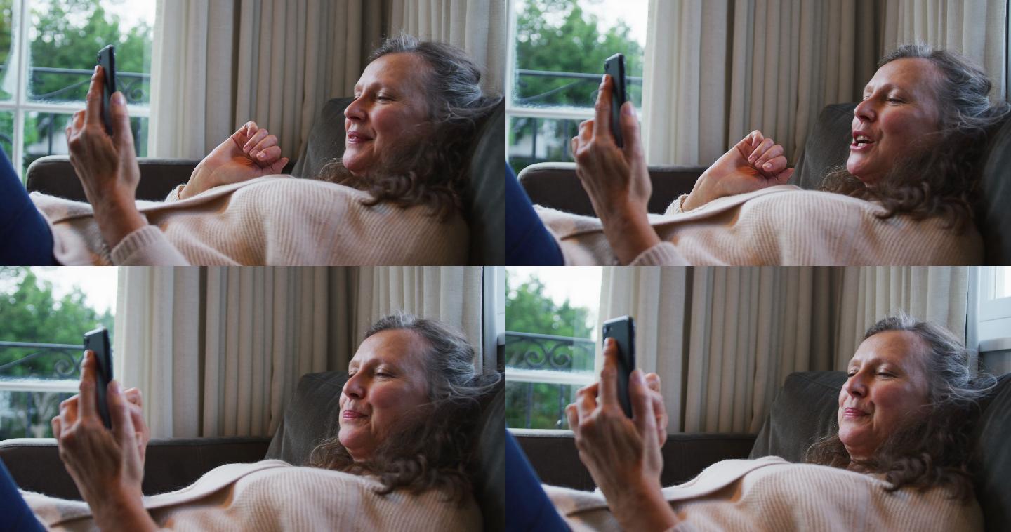 快乐的白人妇女放松和视频通话使用智能手机，交谈和微笑