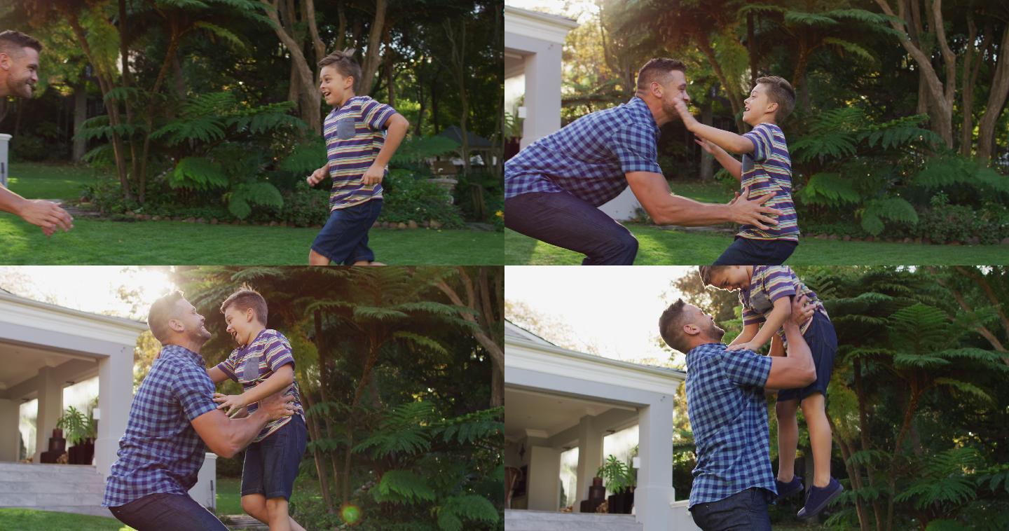 快乐的白种人的儿子跑和跳跃在父亲的怀抱在花园