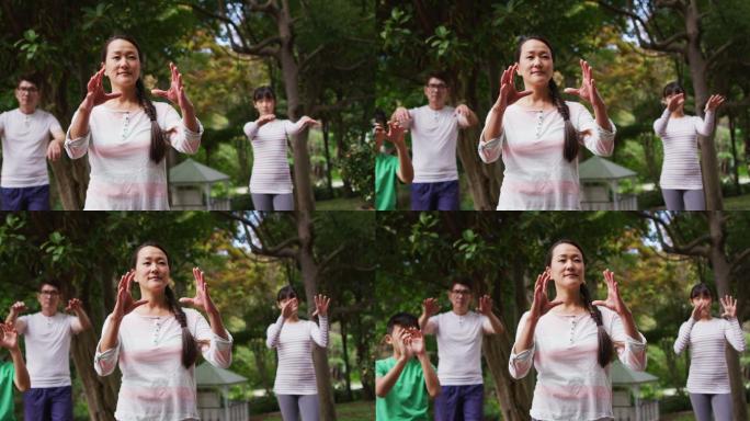 快乐的亚洲父母与儿子和女儿在花园里锻炼，一起练习太极