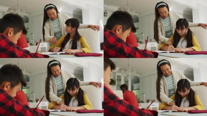 亚洲母亲在厨房帮助儿子和女儿做功课