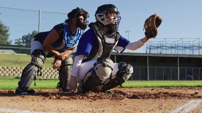 不同团体的女棒球运动员在行动，投球抓住捕手和返回