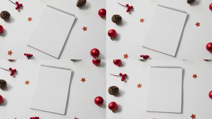 红色圣诞装饰的视频与笔记本在白色背景