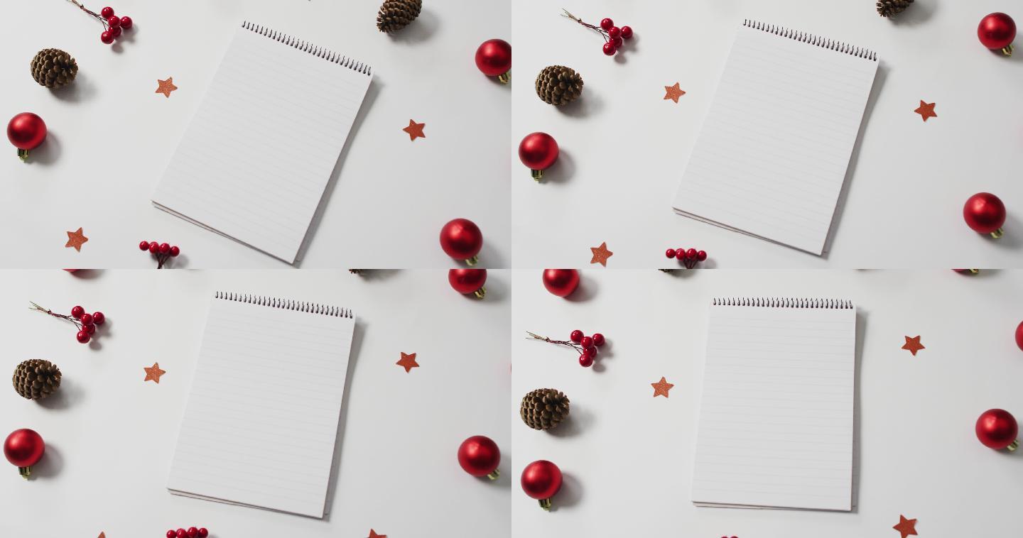 红色圣诞装饰的视频与笔记本在白色背景