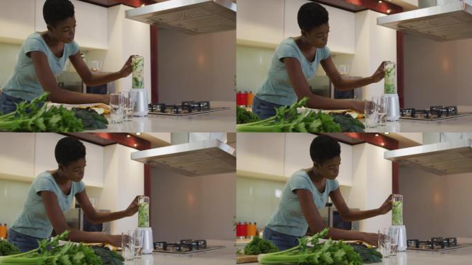 非裔美国人迷人的女人在厨房里为冰沙混合原料