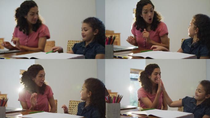 快乐的混血儿妈妈和女儿一起在家里做作业
