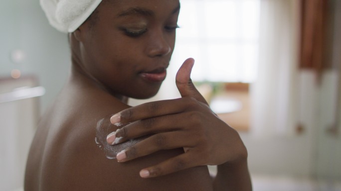 非裔美国人的肖像，有吸引力的女人在浴室里涂体香膏