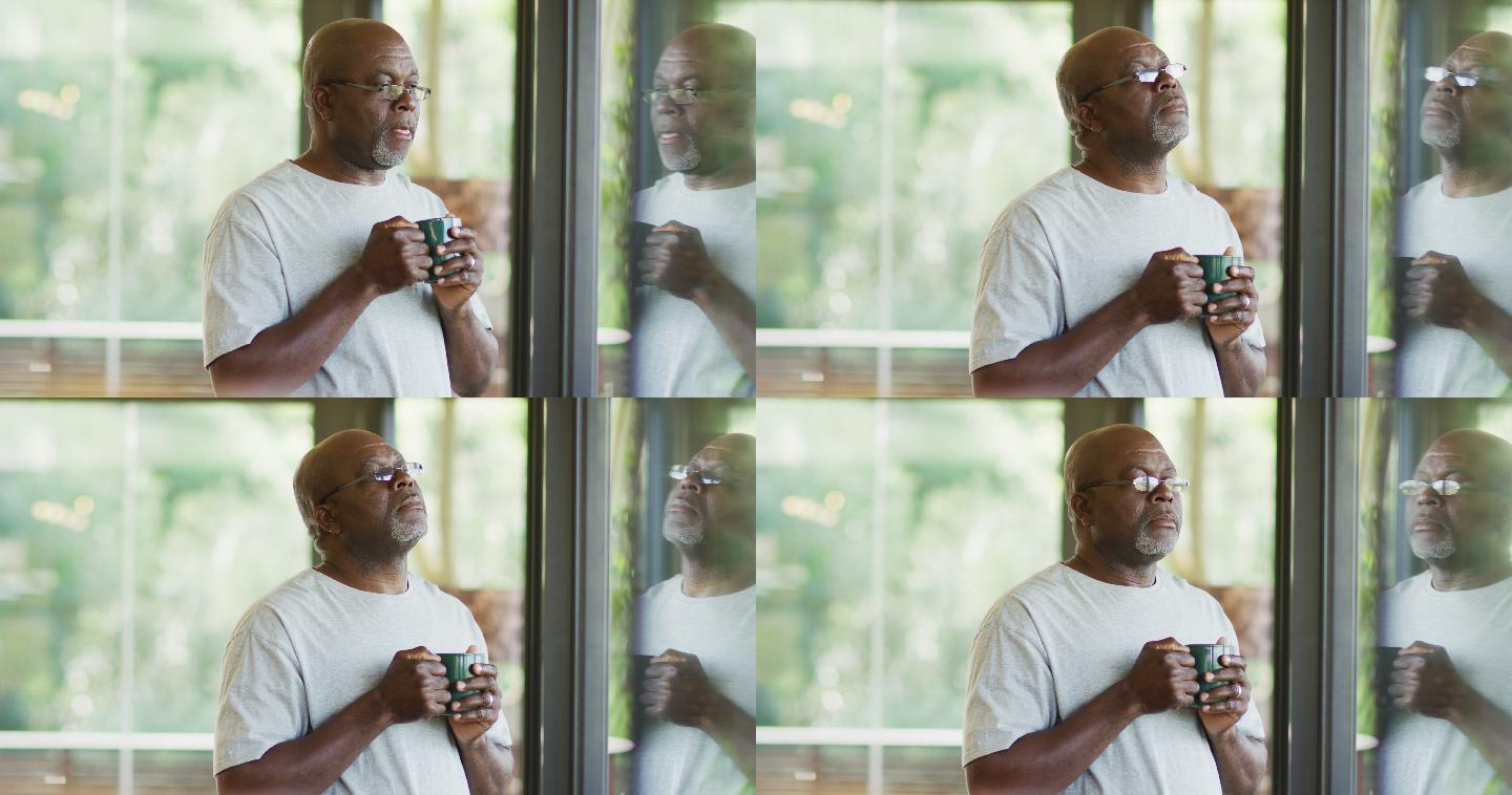 一个深思熟虑的非洲裔美国老人站在那里喝着咖啡，看着窗外