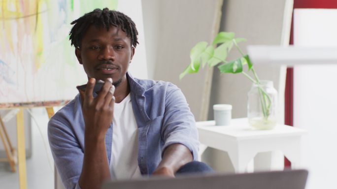 非裔美国男性艺术家在艺术工作室的智能手机上讲话