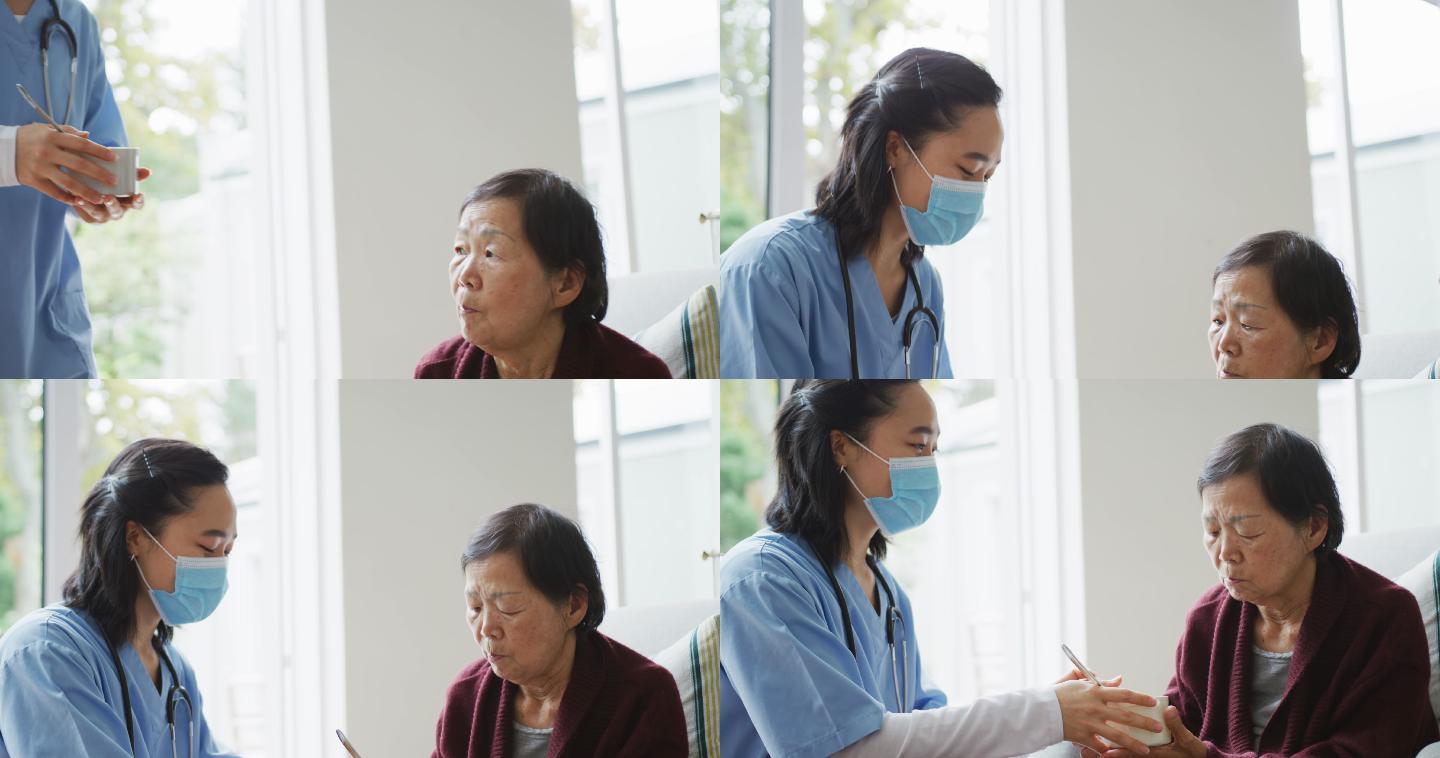 戴着口罩的亚洲女护士给坐在病床上的老年女病人送汤
