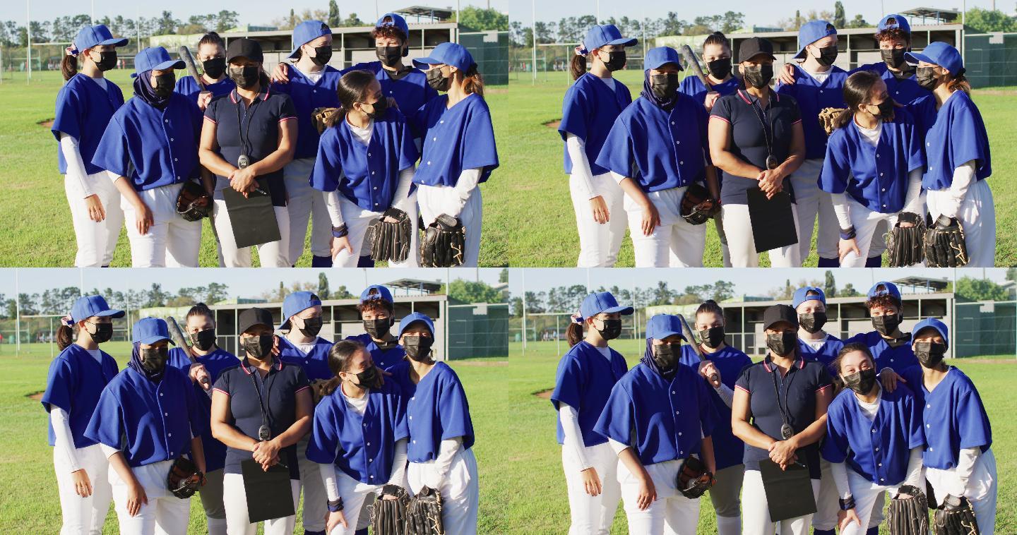 在阳光明媚的球场上，戴着口罩的女棒球队员和教练组成了不同的队伍