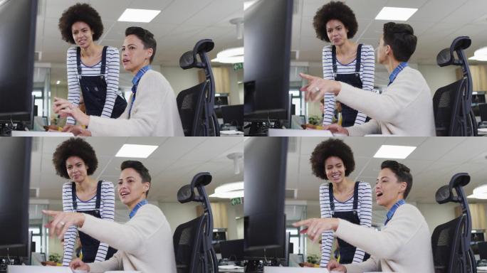 各种微笑的女商务同事指着电脑，在办公室里讨论
