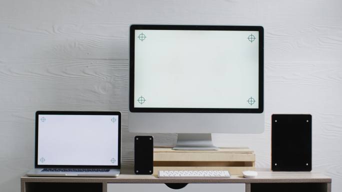 笔记本电脑、智能手机、平板电脑和电脑的视频放在木制桌子上，办公室里有复印空间