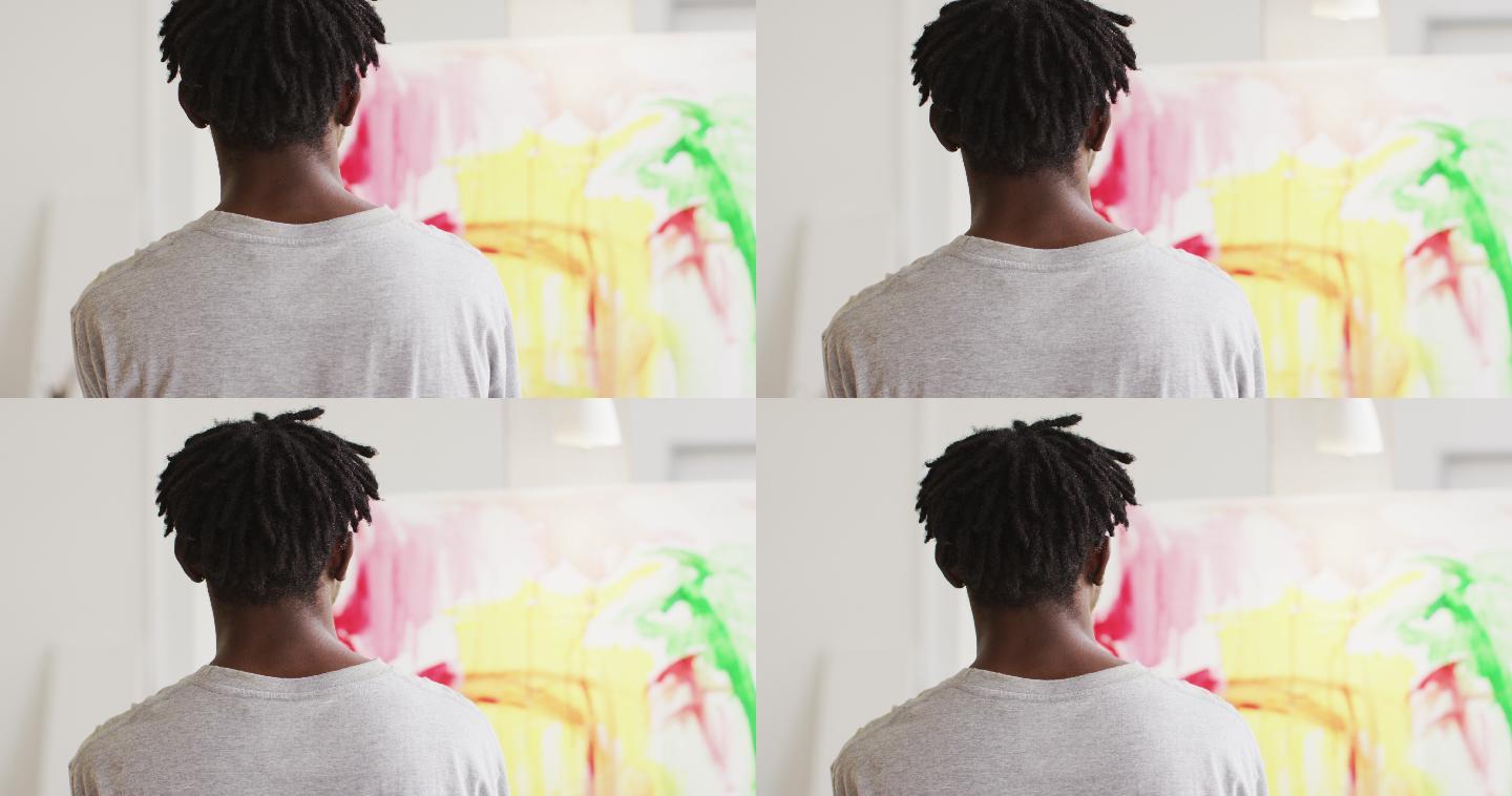 后视图的非洲裔美国男性艺术家在画布上绘画在艺术工作室