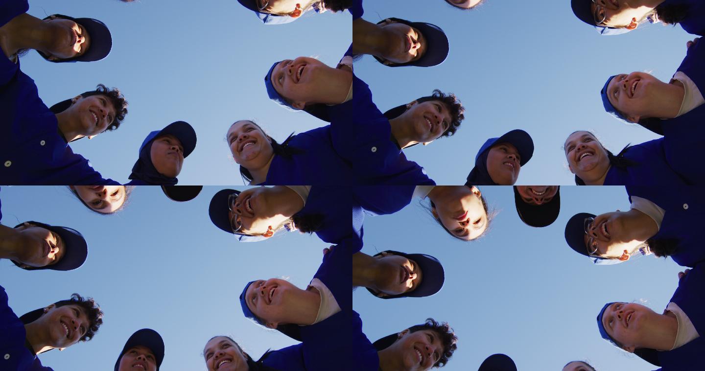 低角度的看法，不同的组女棒球运动员在一个拥挤的蓝天