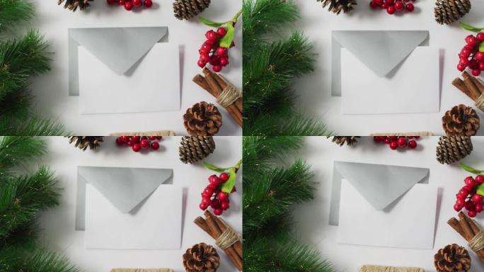 圣诞松果、圣诞树和红浆果装饰的视频，白色背景上的信封
