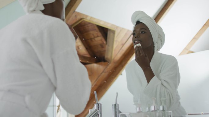 非裔美国人迷人的女人在浴室里卸妆