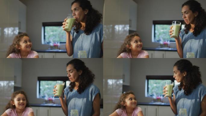 混血母亲和女儿在厨房喝冰沙