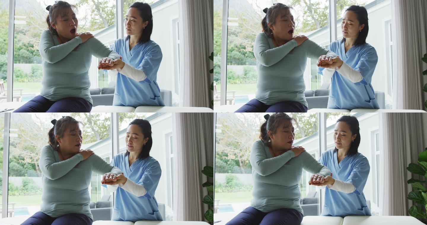 亚洲女性理疗师在手术中治疗女性患者，移动她的手臂