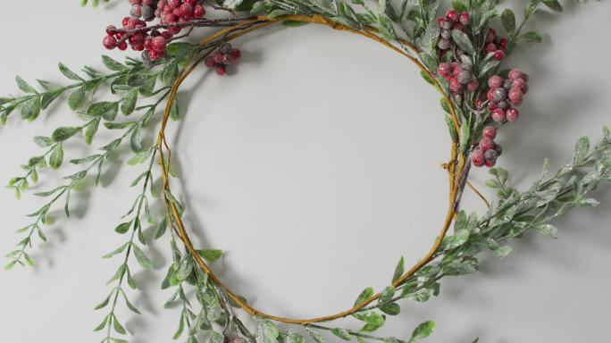 圆形圣诞树叶和浆果装饰的视频与白色背景复制空间