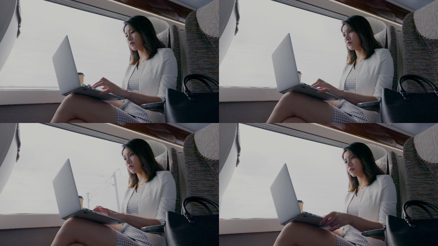 年轻商务女士在高铁上使用笔记本电脑