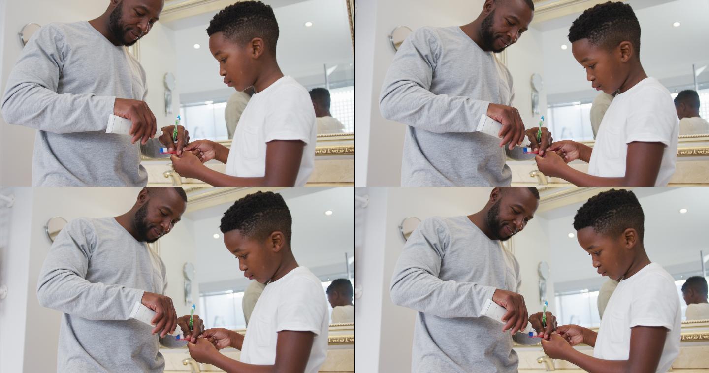 非裔美国父亲把牙膏在他儿子的刷子在浴室在家里