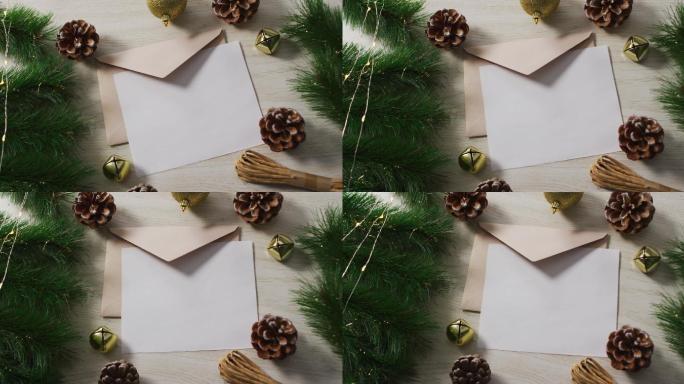 圣诞装饰的视频与白色卡片和米色信封在木制背景