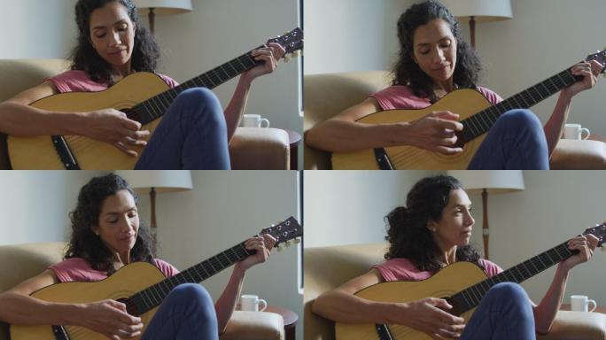 快乐的混血儿女人坐在沙发上弹吉他