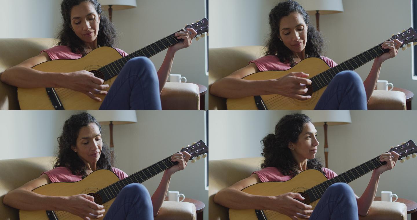 快乐的混血儿女人坐在沙发上弹吉他