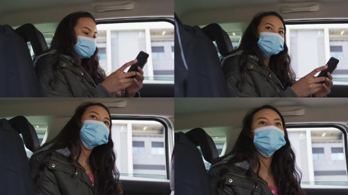 戴着口罩坐在车里使用智能手机的亚洲女性