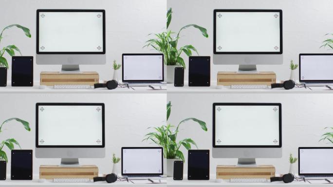 笔记本电脑、智能手机、平板电脑和电脑的视频放在木制桌子上，办公室里有复印空间